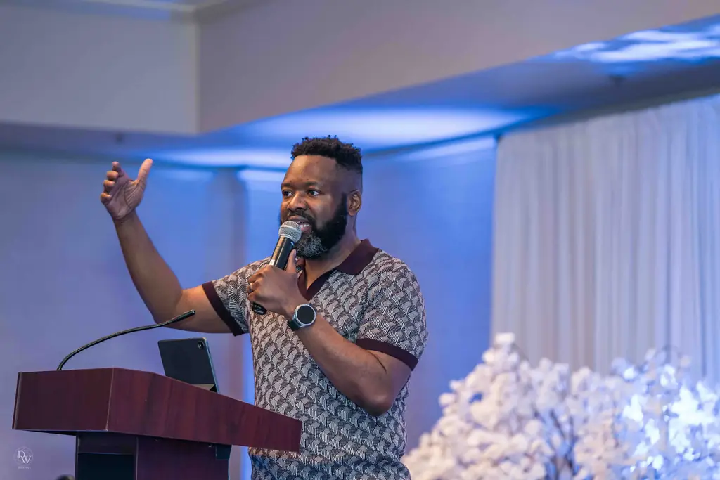 A preacher speaking with his hand raised