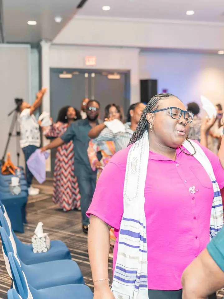 A woman praising joyfully with her arms raised
